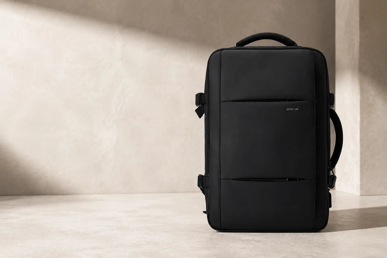 Black expandable backpack in a warm stone studio